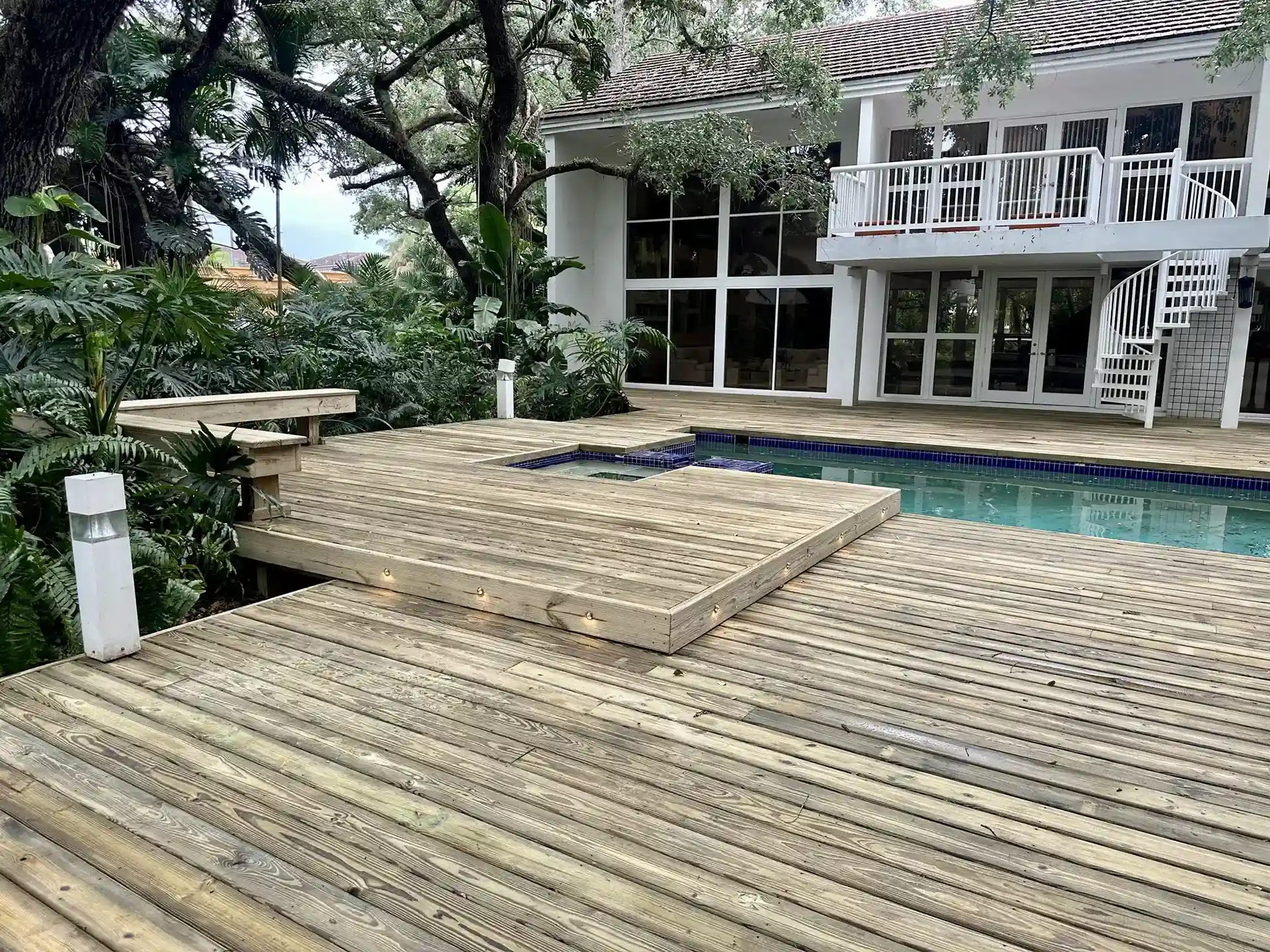 Photo of a wooden pool deck showing signs of age, making it a candidate for deck remodeling or deck resurfacing